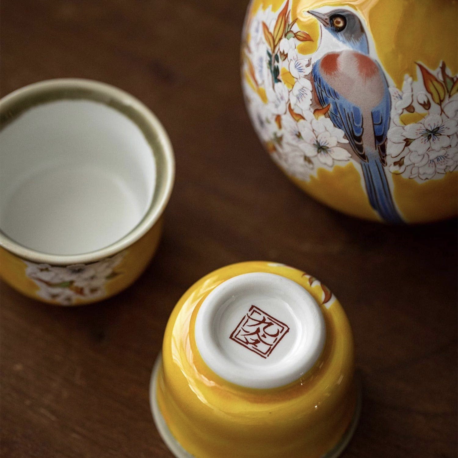 Hand-painted sake drinking set featuring intricate nature motifs.
