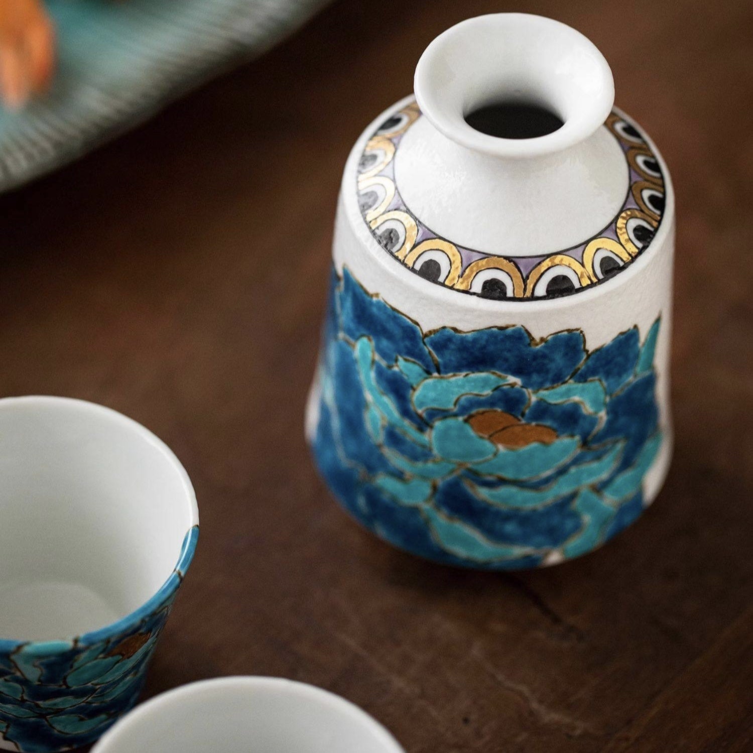 Artistic sake set featuring a peony motif on a serving tray.
