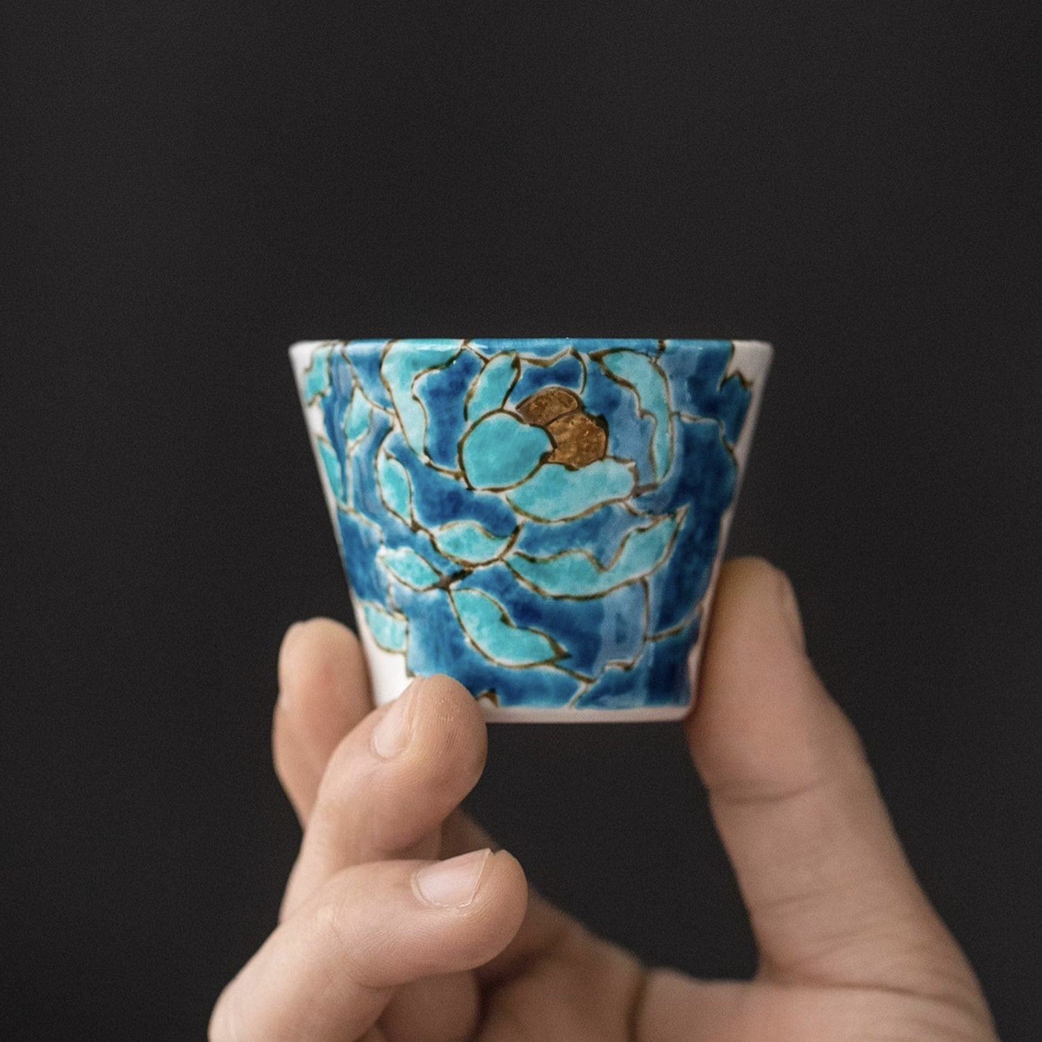 Close-up of blue peony design on ceramic sake cups.
