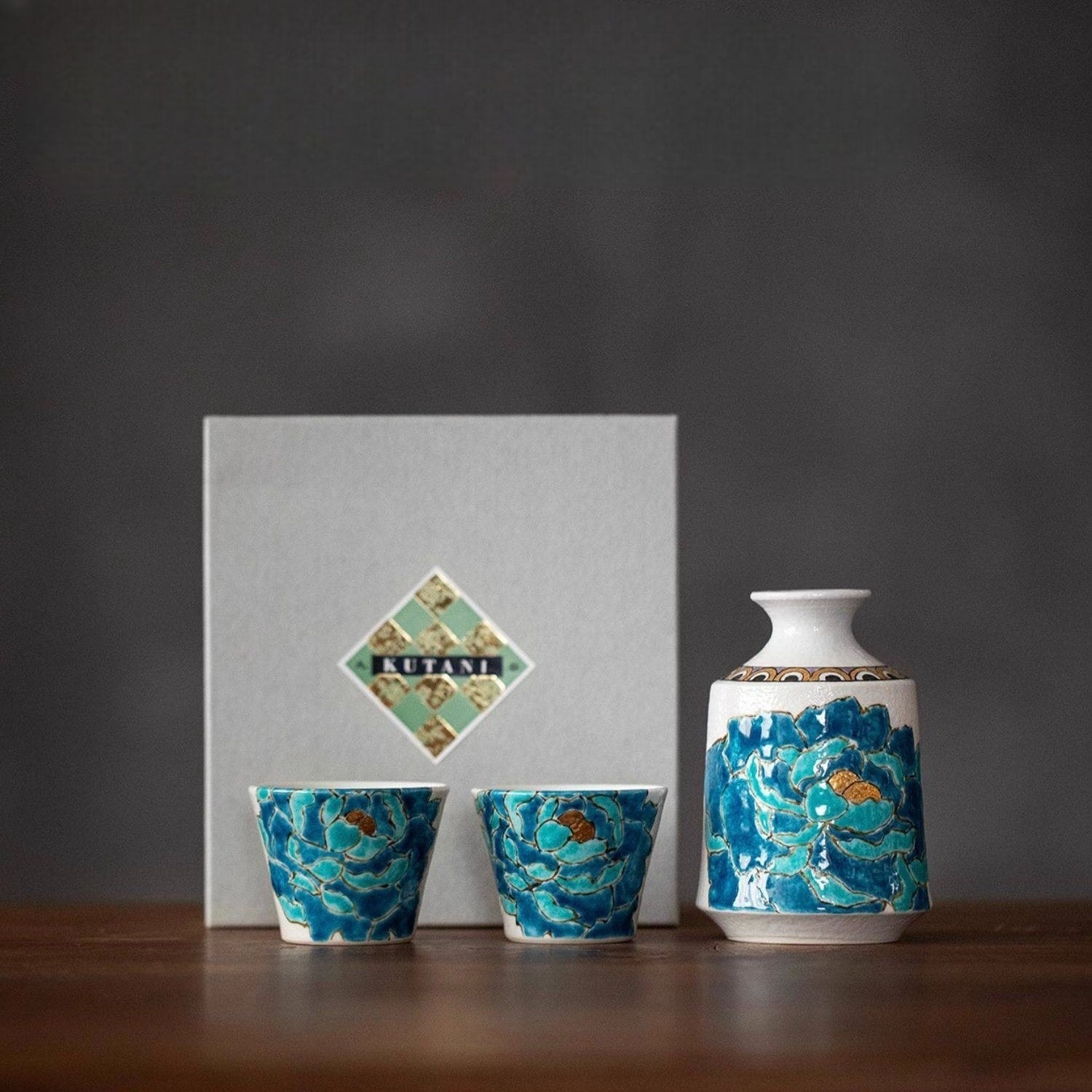 Ceramic sake set with vibrant blue peony and gold accents.
