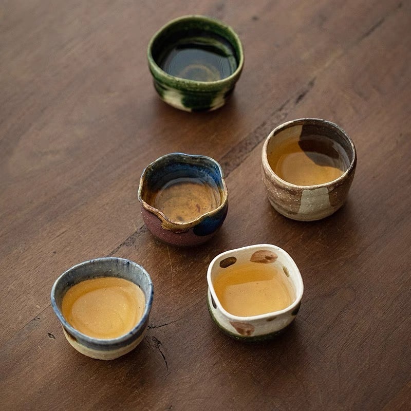 Artisan-crafted sake cups displaying irregular edges and natural textures.
