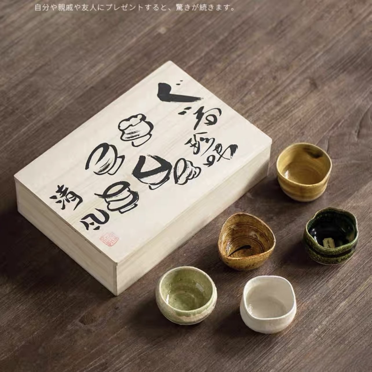 Unique sake cup set displayed with a traditional wooden gift box.
