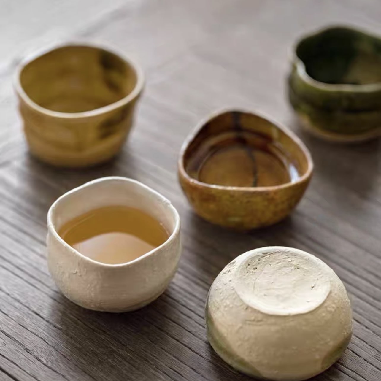 Artistic sake cup collection embracing the Wabi-Sabi aesthetic.
