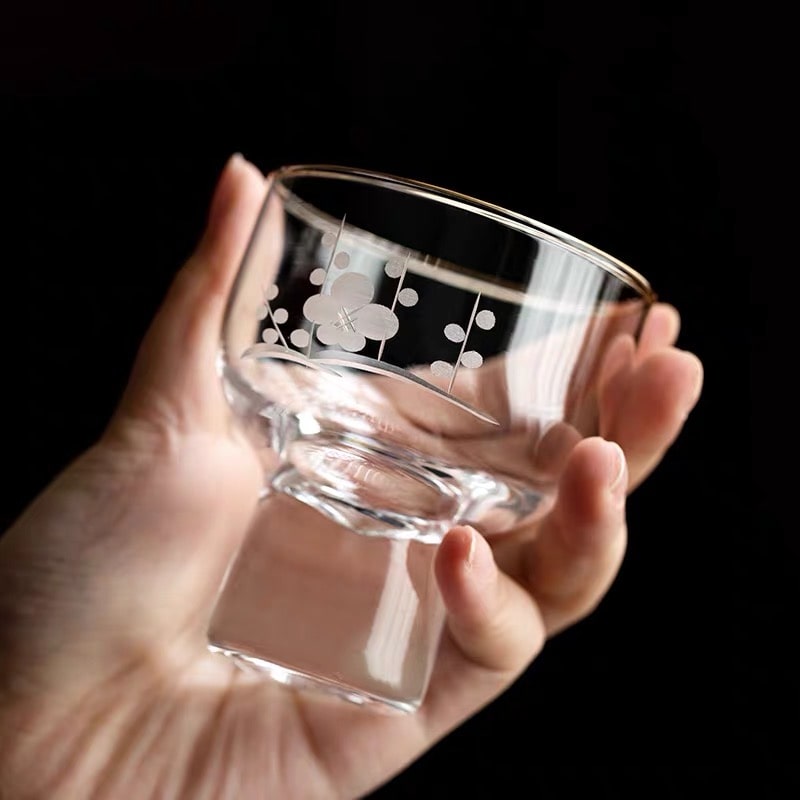 Close-up of engraved Mt. Fuji design on a glass sake cup.
