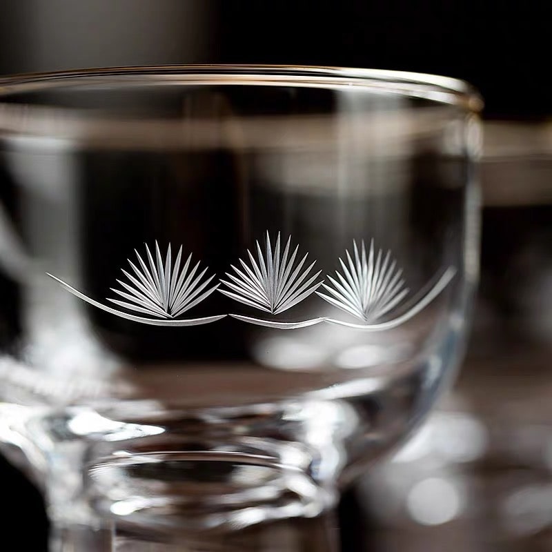 Elegant glass sake cups displayed with a wooden box.
