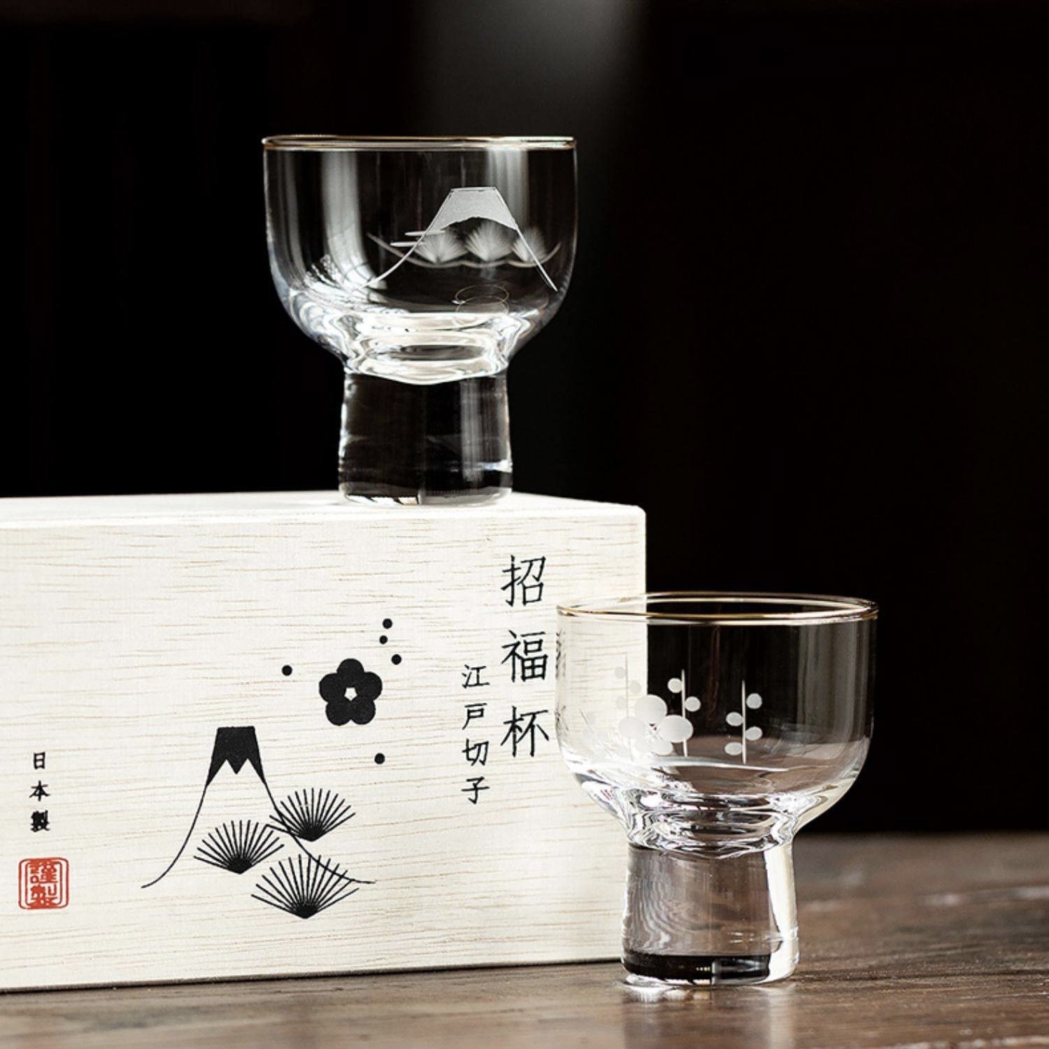 Glass sake cups with Mt. Fuji and cherry blossom engravings.
