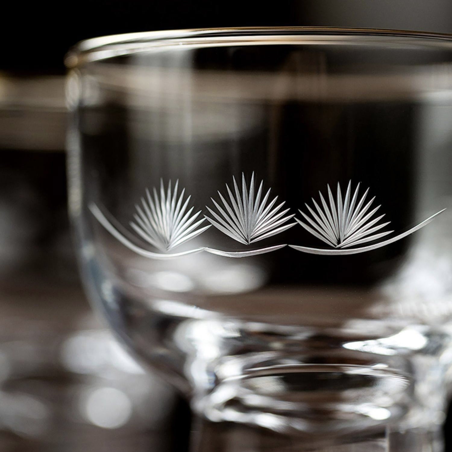 Elegant glass sake cups displayed with a wooden box.
