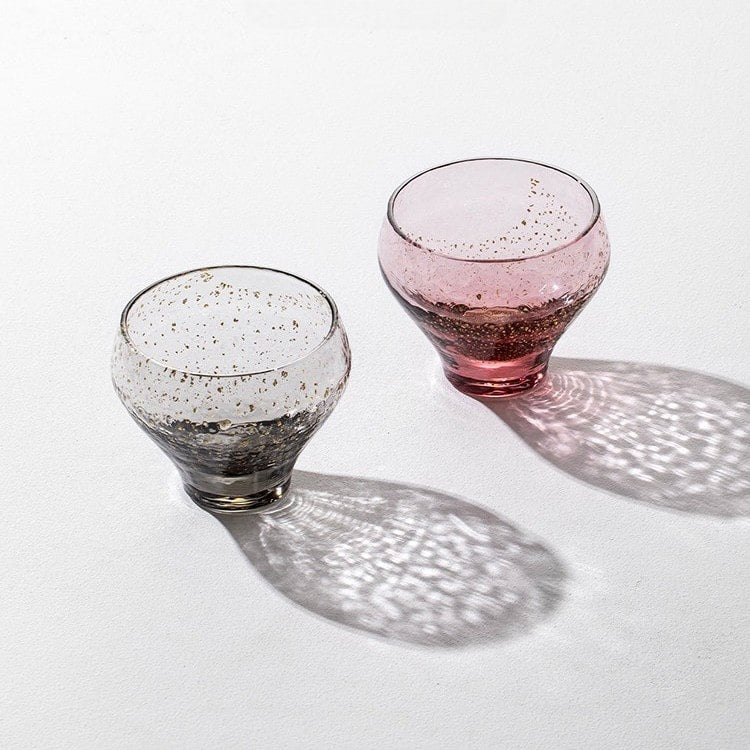 Transparent glass sake cup with embedded gold flecks.
