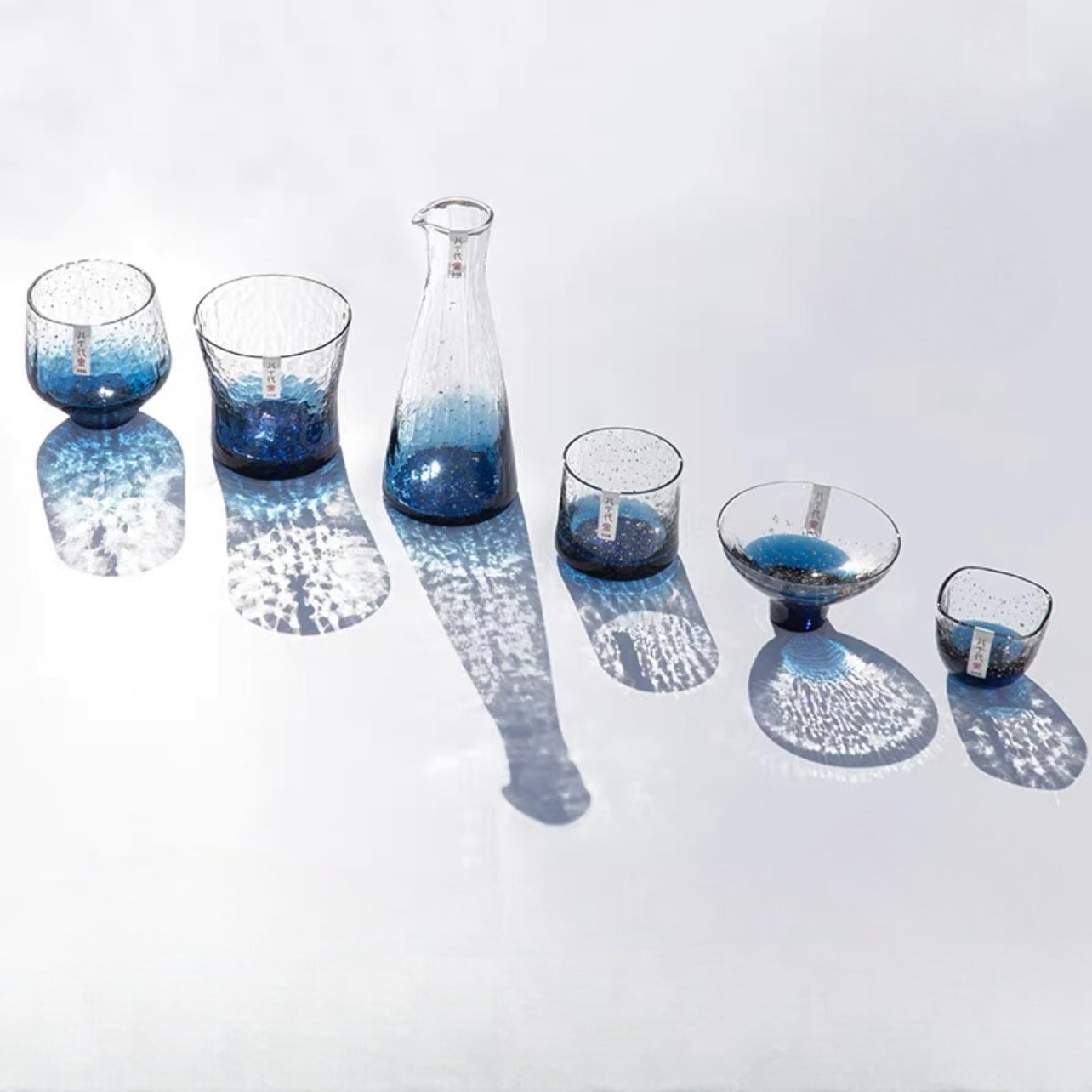 Complete glass sake set with blue gradient and gold speckled accents.
