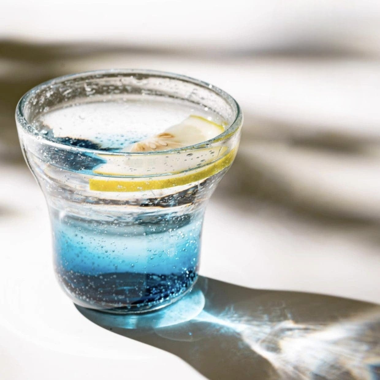 Hand-blown blue gradient cocktail glasses with bubble detailing.
