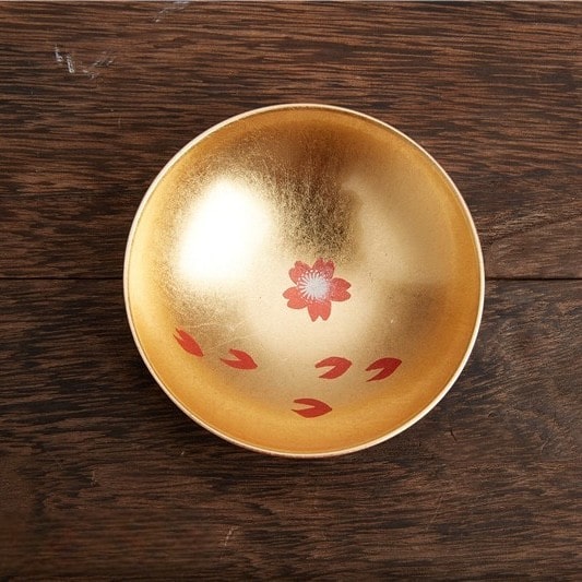 Handcrafted lacquerware sake cups with intricate and playful designs.
