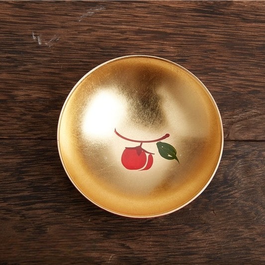 Handcrafted lacquerware sake cups with intricate and playful designs.
