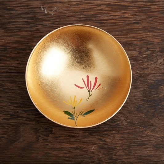 Handcrafted lacquerware sake cups with intricate and playful designs.
