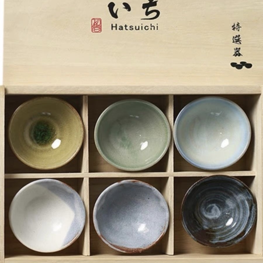 Close-up of handcrafted ceramic sake cups with varied textures.
