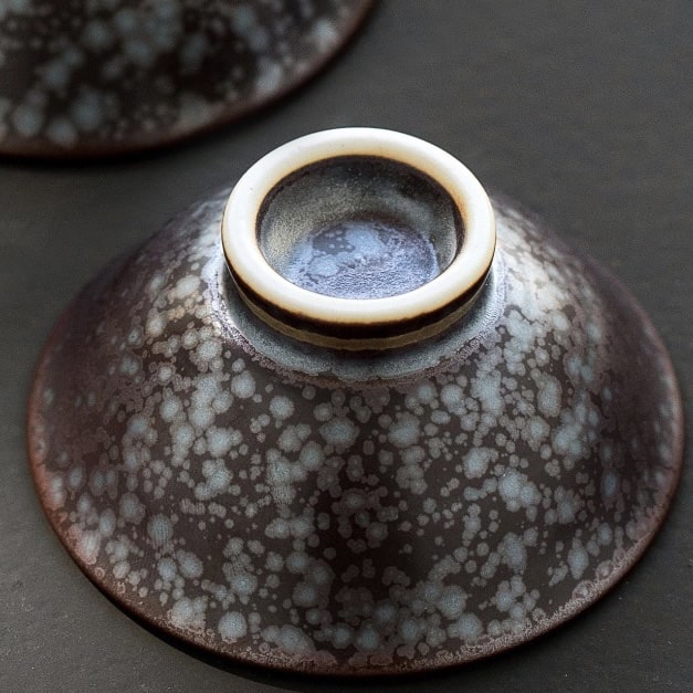 Close-up of Japanese sake cups featuring distinct artisan designs.
