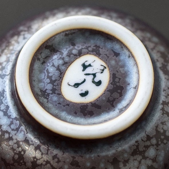 Close-up of Japanese sake cups featuring distinct artisan designs.
