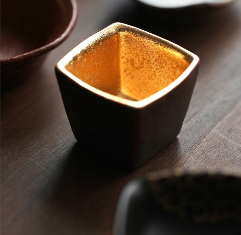 Close-up of Japanese sake cups featuring distinct artisan designs.
