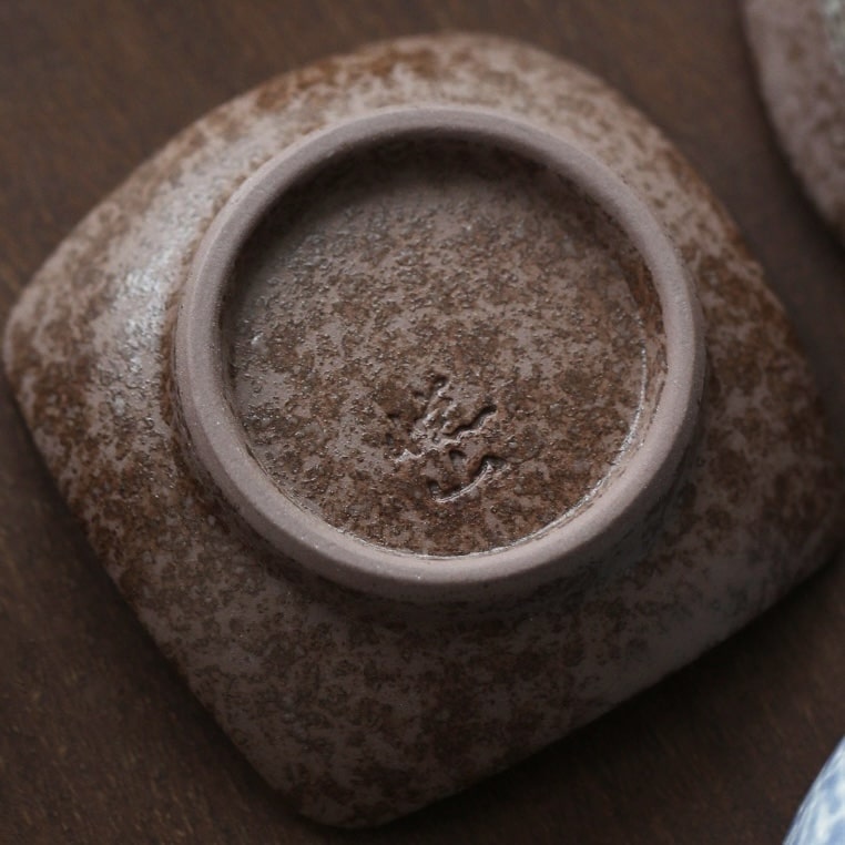 Close-up of Japanese sake cups featuring distinct artisan designs.
