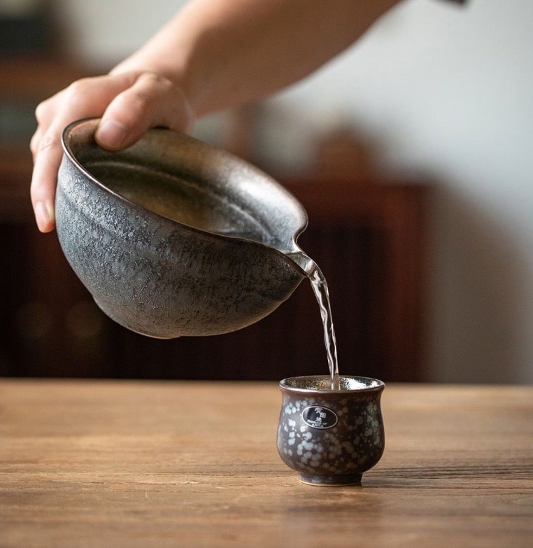 Japanese handcrafted tea cup set with varied textures displayed on a neutral surface.
