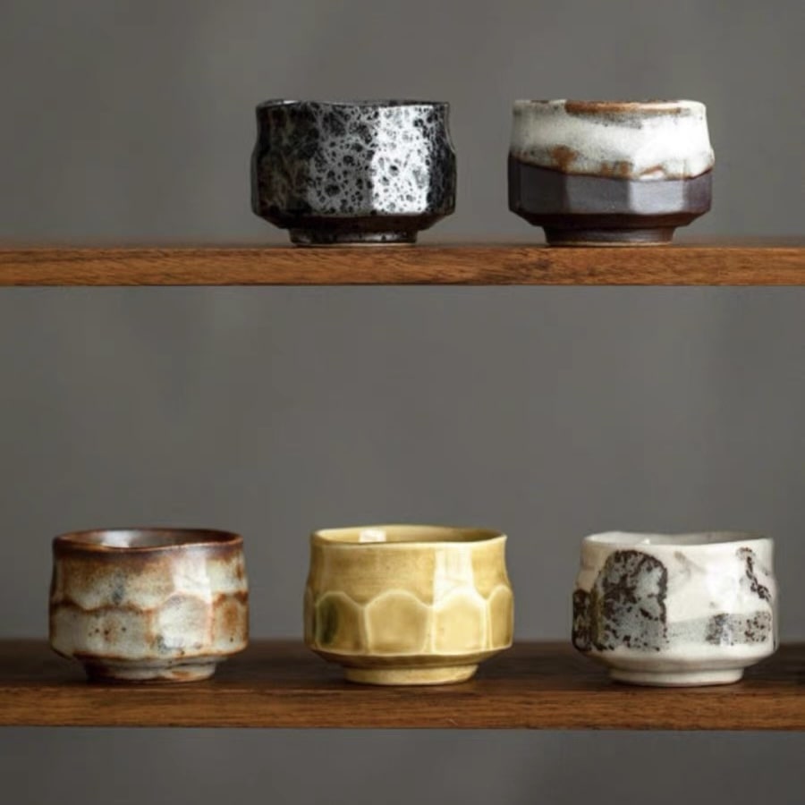 Five uniquely designed ceramic tea cups in muted and warm colors.
