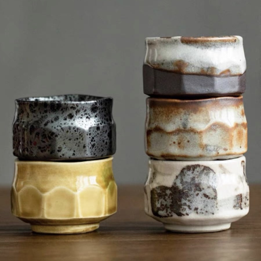 Set of handcrafted ceramic tea cups with textured finishes and earthy tones.
