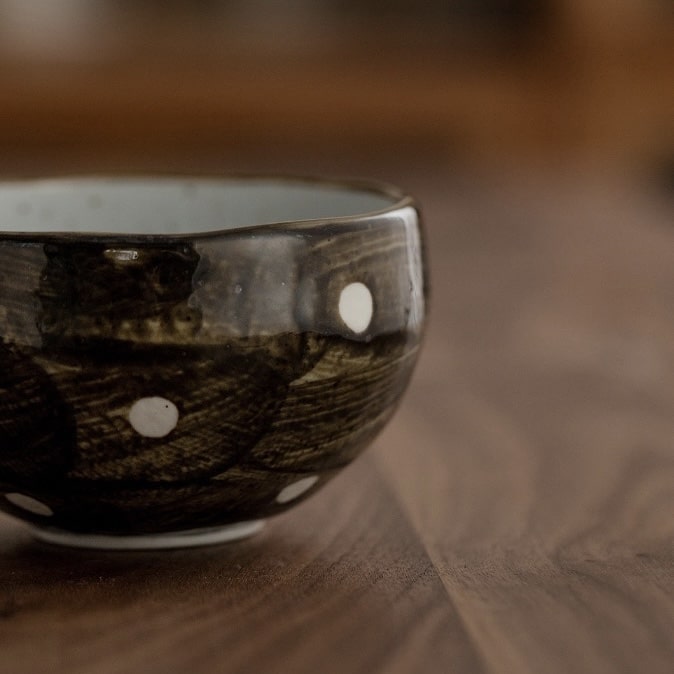 Close-up of artisan tea cups featuring unique glaze patterns.
