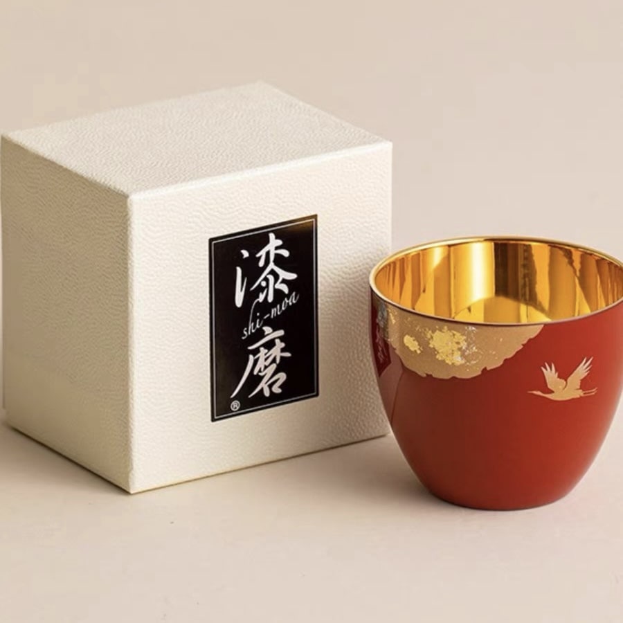 Japanese lacquerware tea cups with gold-leaf interiors in red and black.
