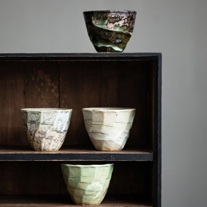 Elegant tea cups with organic textures and earthy tones.
