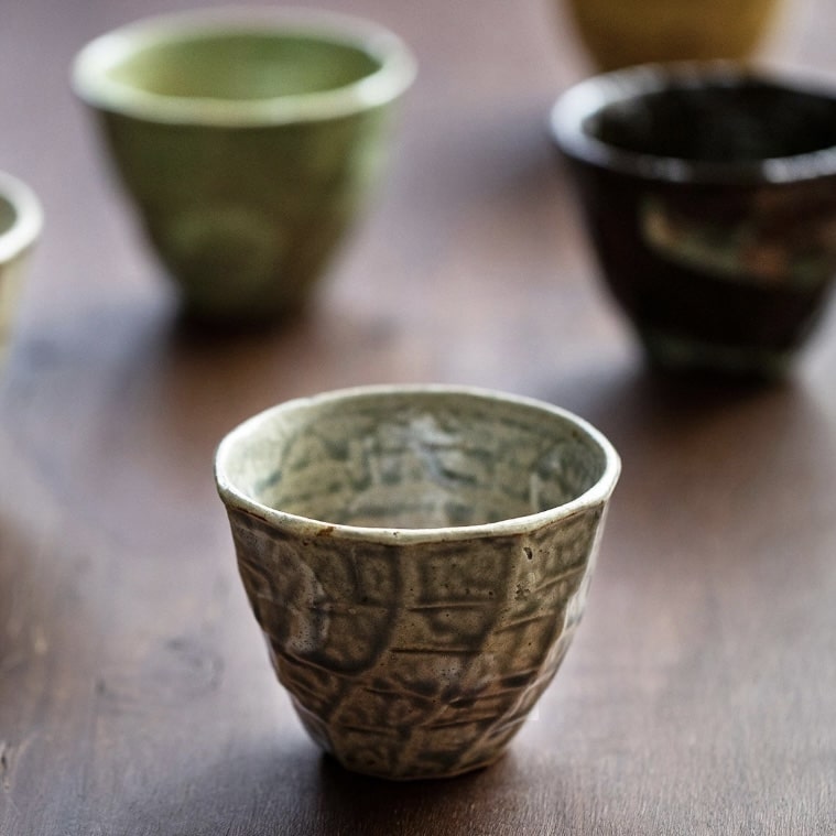 Artisan tea cup collection featuring unique natural-inspired designs.
