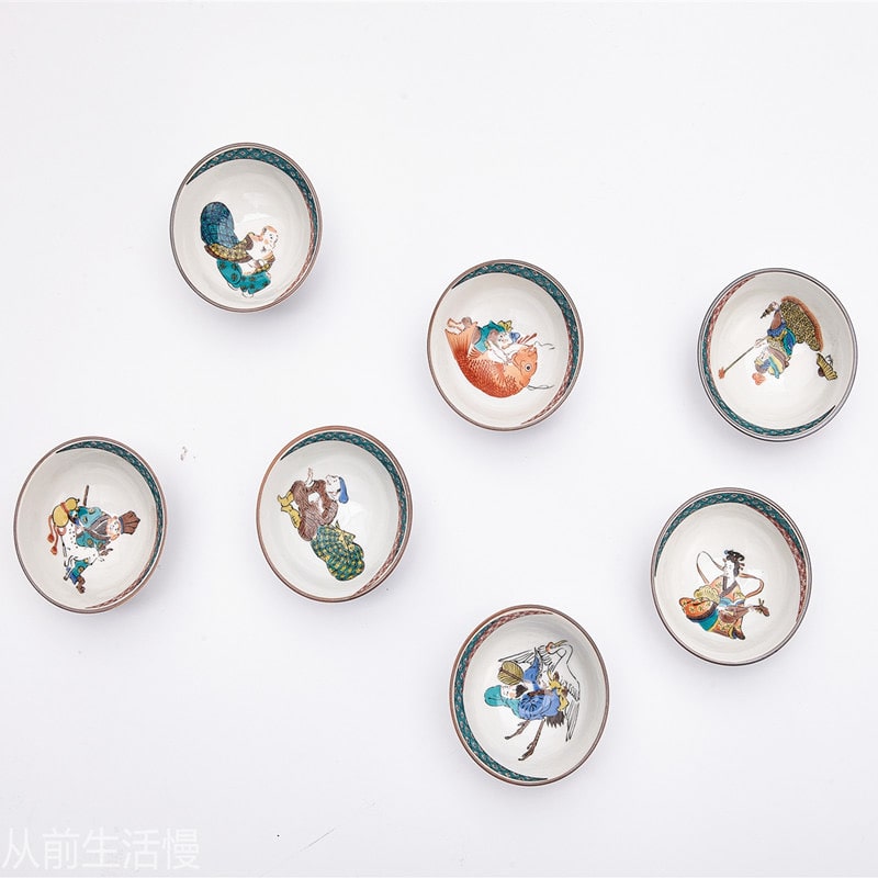 Detailed porcelain tea cups featuring colorful traditional artwork.
