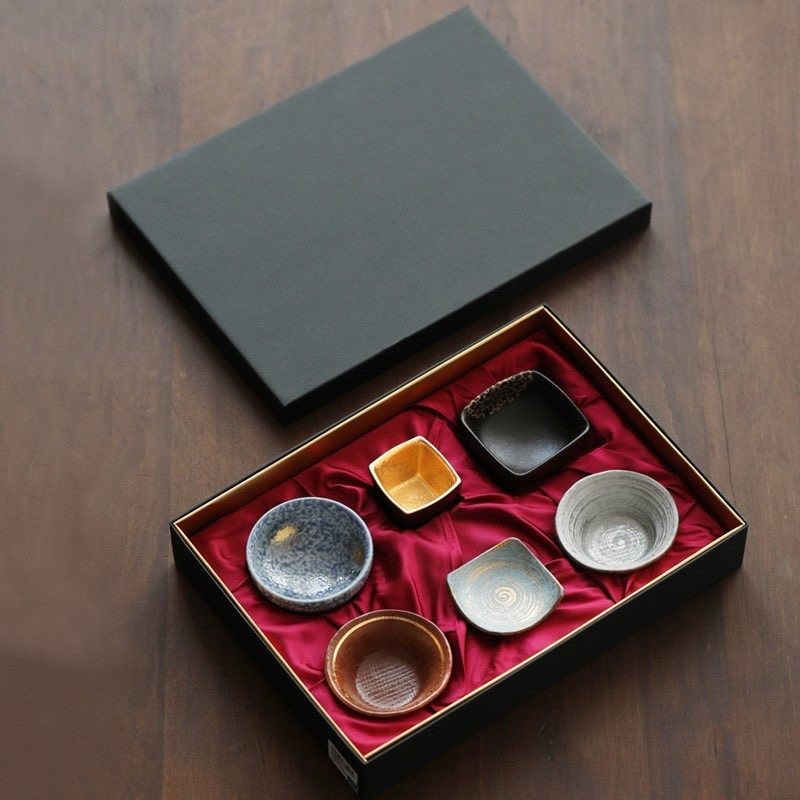 Ceramic sake set with six artisan-crafted cups in a black gift box.
