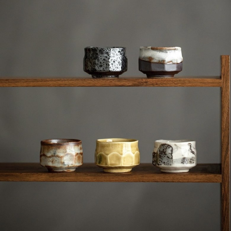 Stackable rustic ceramic tea cups with artisanal textures.
