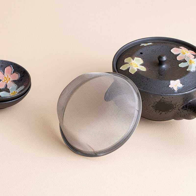 Sakura-inspired black ceramic teaset with cherry blossom designs.