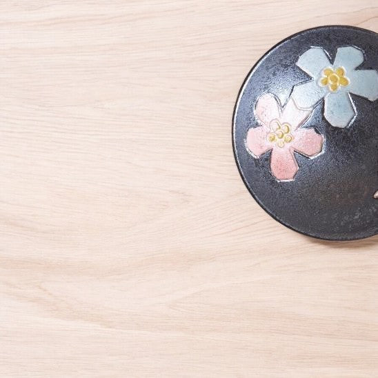 Sakura-inspired black ceramic teaset with cherry blossom designs.