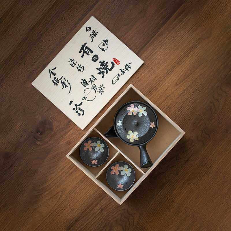 Sakura-inspired black ceramic teaset with cherry blossom designs.