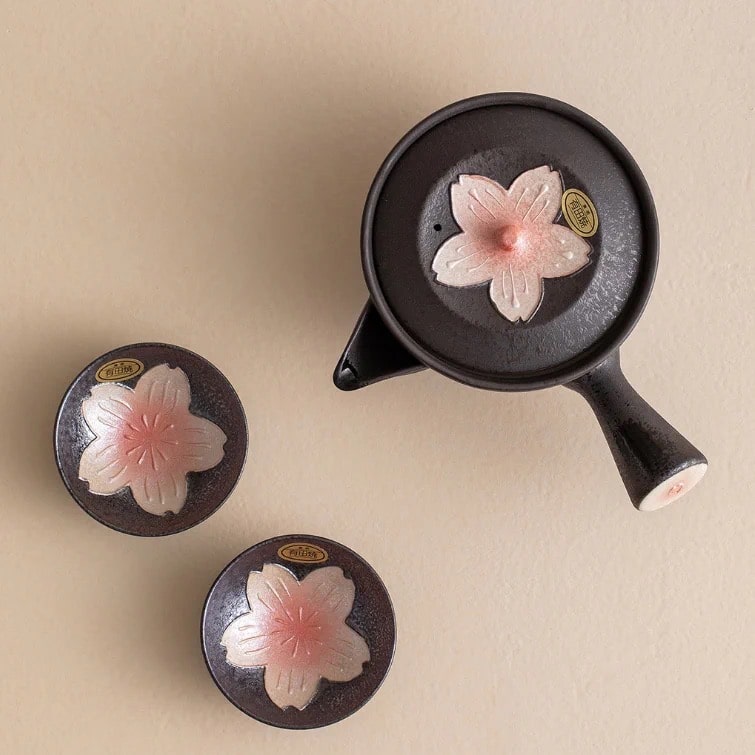 Traditional Japanese ceramic tea set with cherry blossom accents and decorative cards.