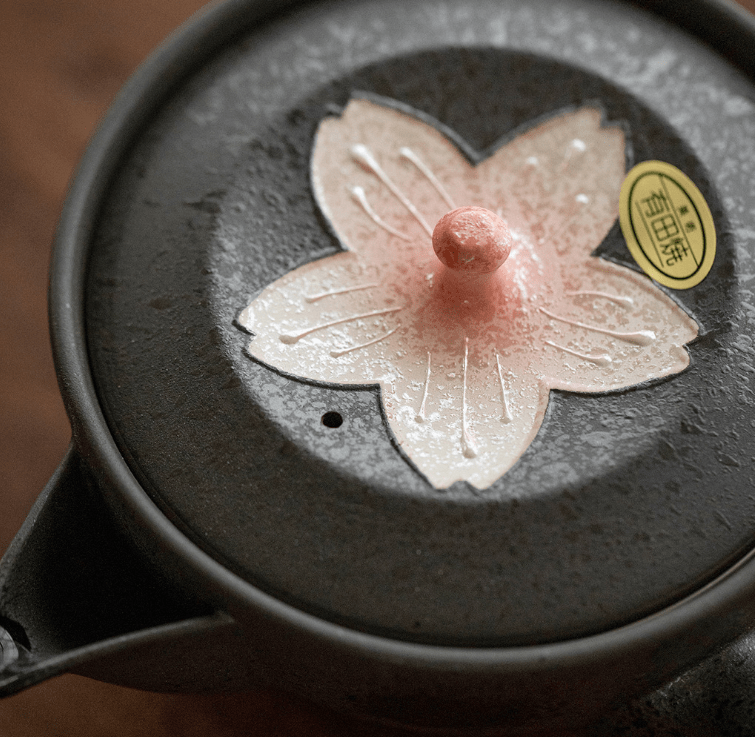 Close-up of cherry blossom design on handcrafted Japanese teacups.