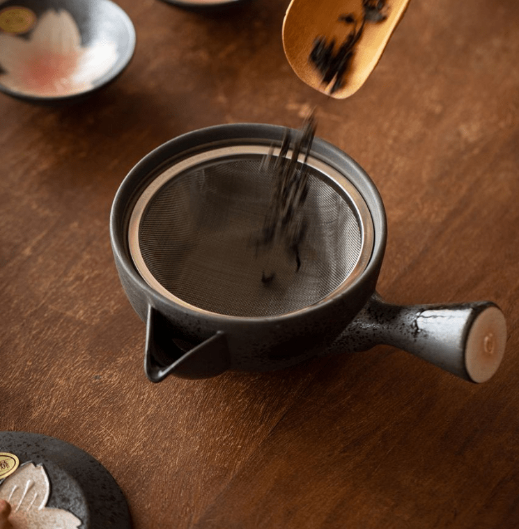 Sakura-themed ceramic teapot and cup set displayed elegantly with gift packaging.