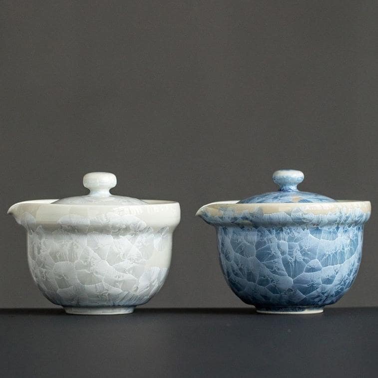 Pair of blue and white ceramic tea cups with intricate crackle glaze design.