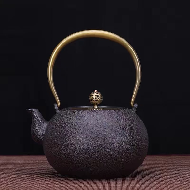 Premium cast iron tea pot showcasing a spherical design and brass accents.