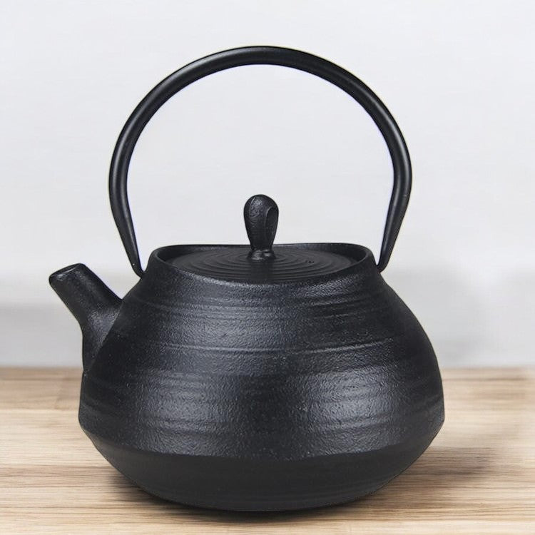 Black cast iron teapot with an ergonomic handle