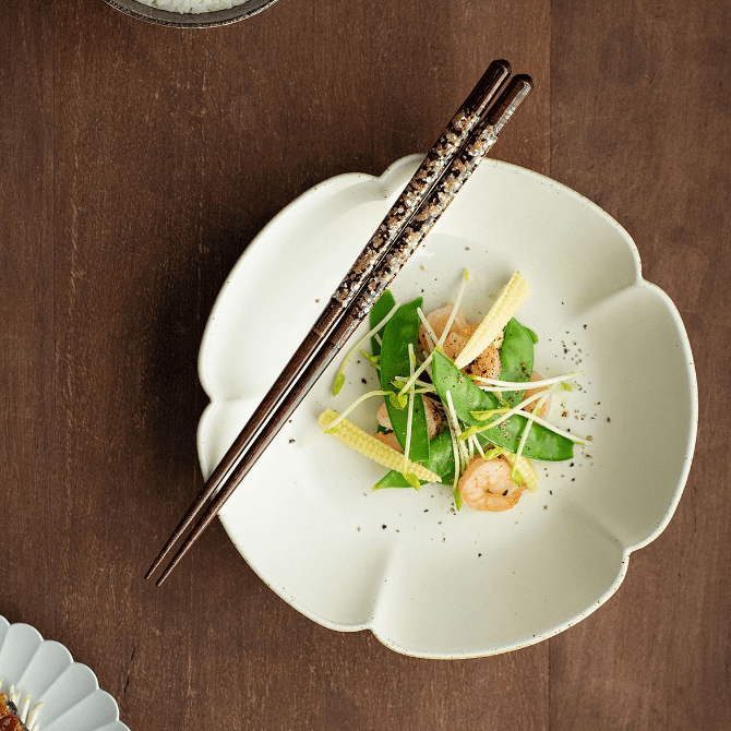 Close-up of handcrafted red and gold chopsticks with inlay details