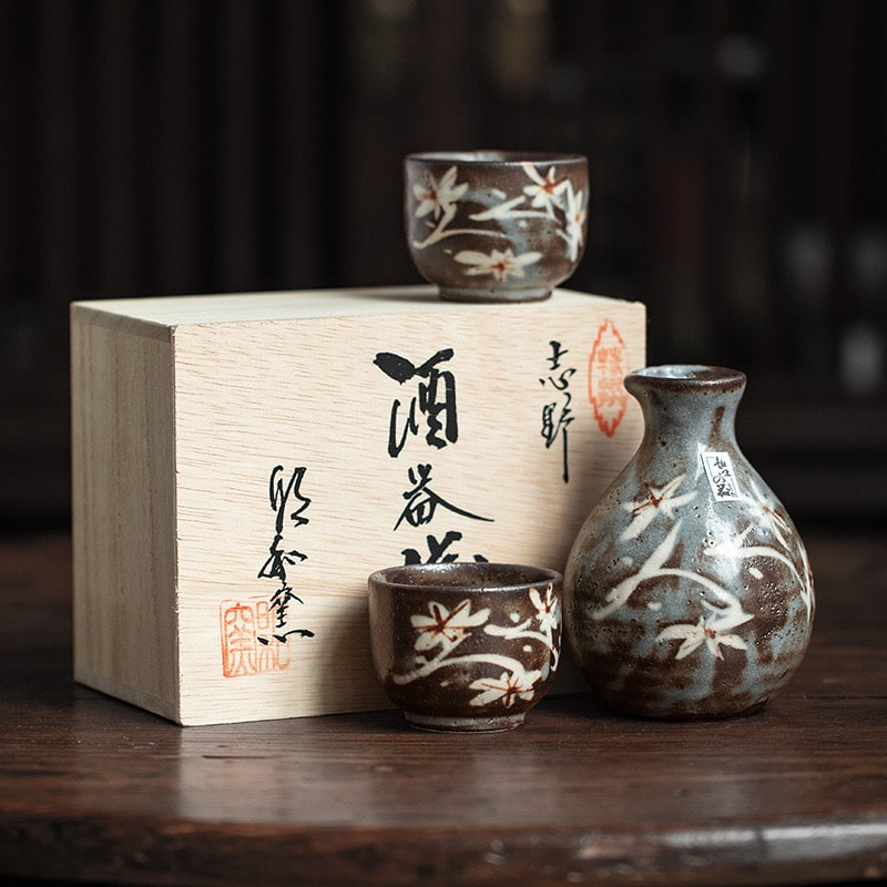 Hand holding a ceramic Ochoko cup filled with sake