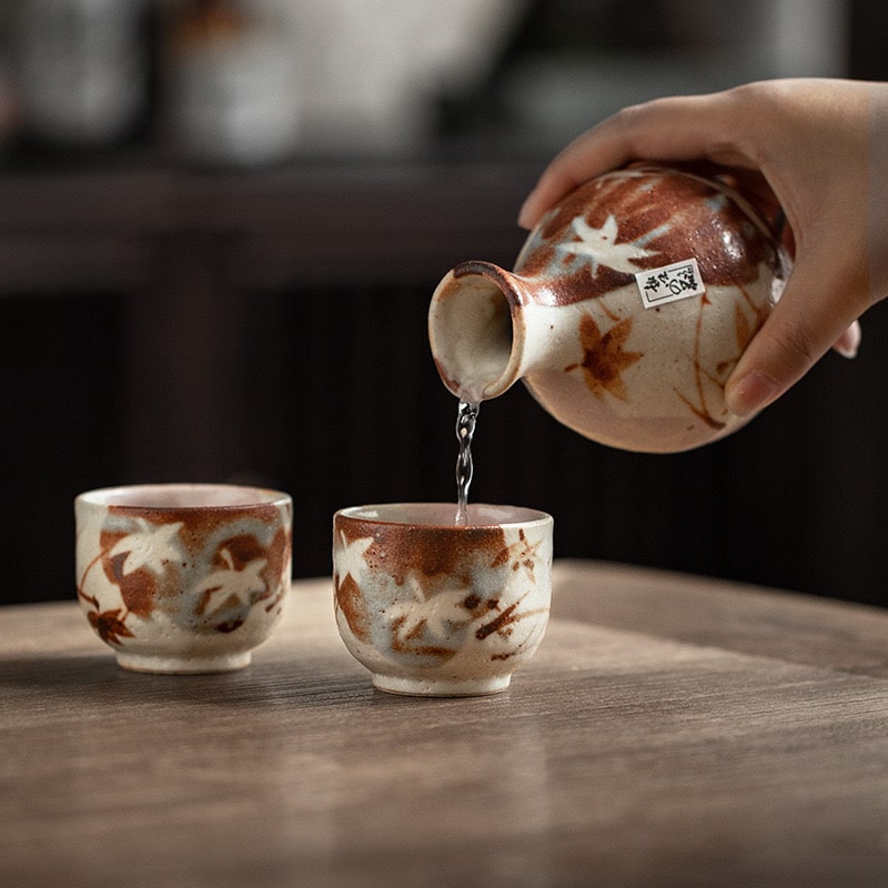 Close-up of a Tokkuri sake bottle being poured into a ceramic cup