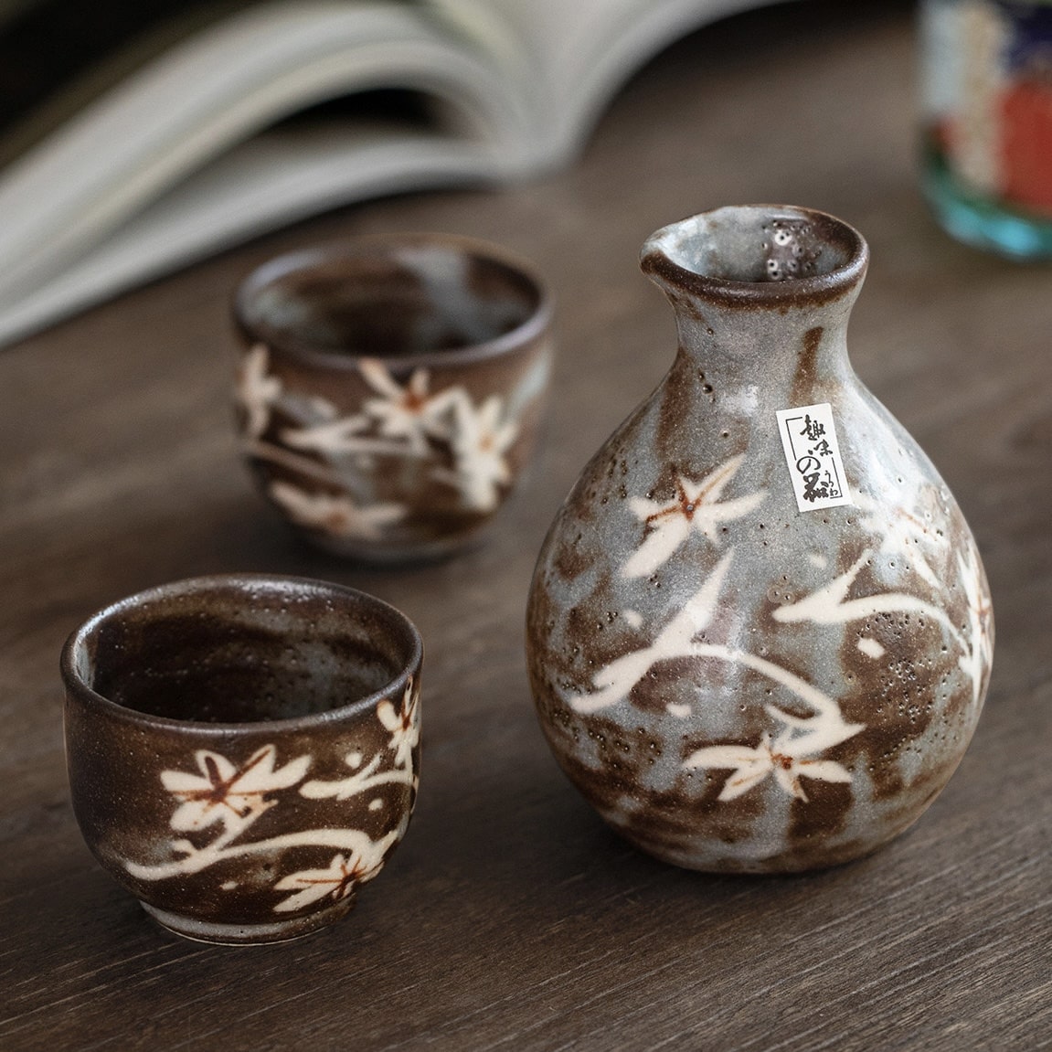 Hand holding a ceramic Ochoko cup filled with sake