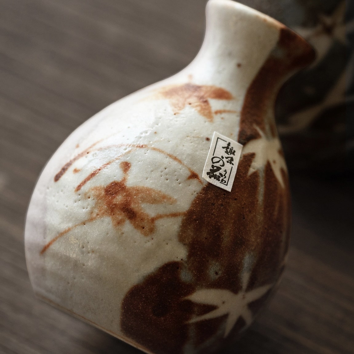 Close-up of a Tokkuri sake bottle being poured into a ceramic cup