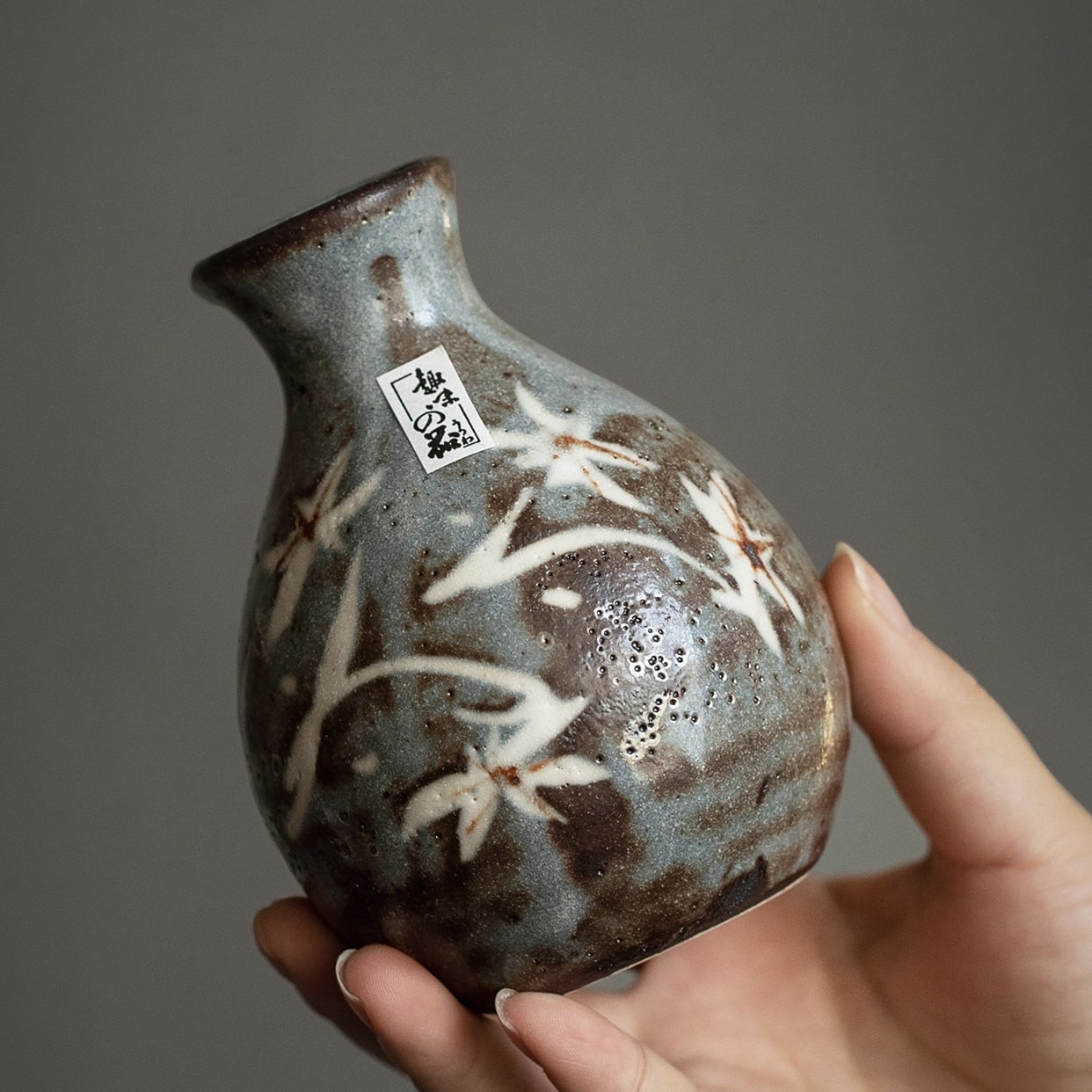 Full ceramic sake set with Tokkuri and two Ochoko cups on display