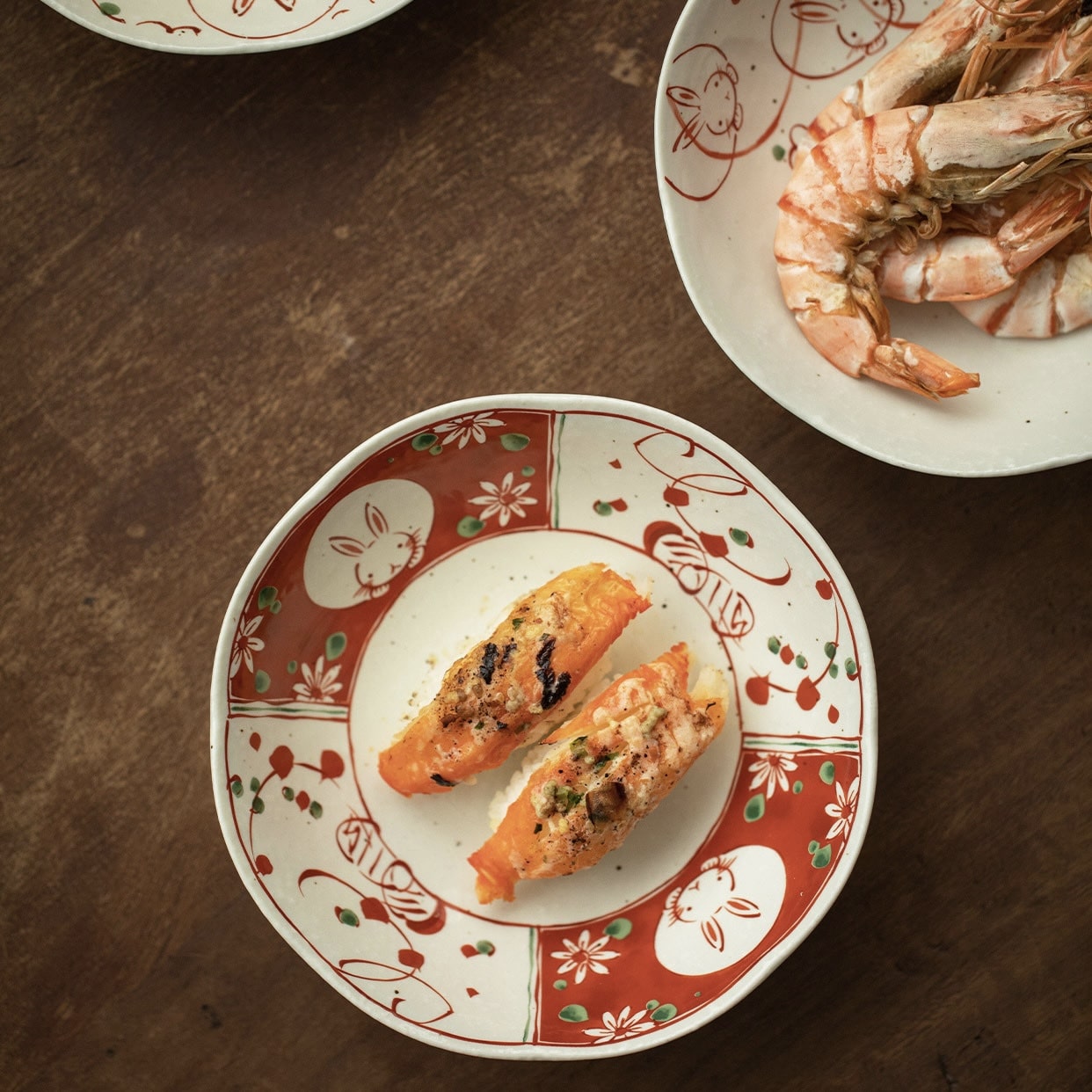 Stack of rabbit ceramic dishes in red and white on a wooden table