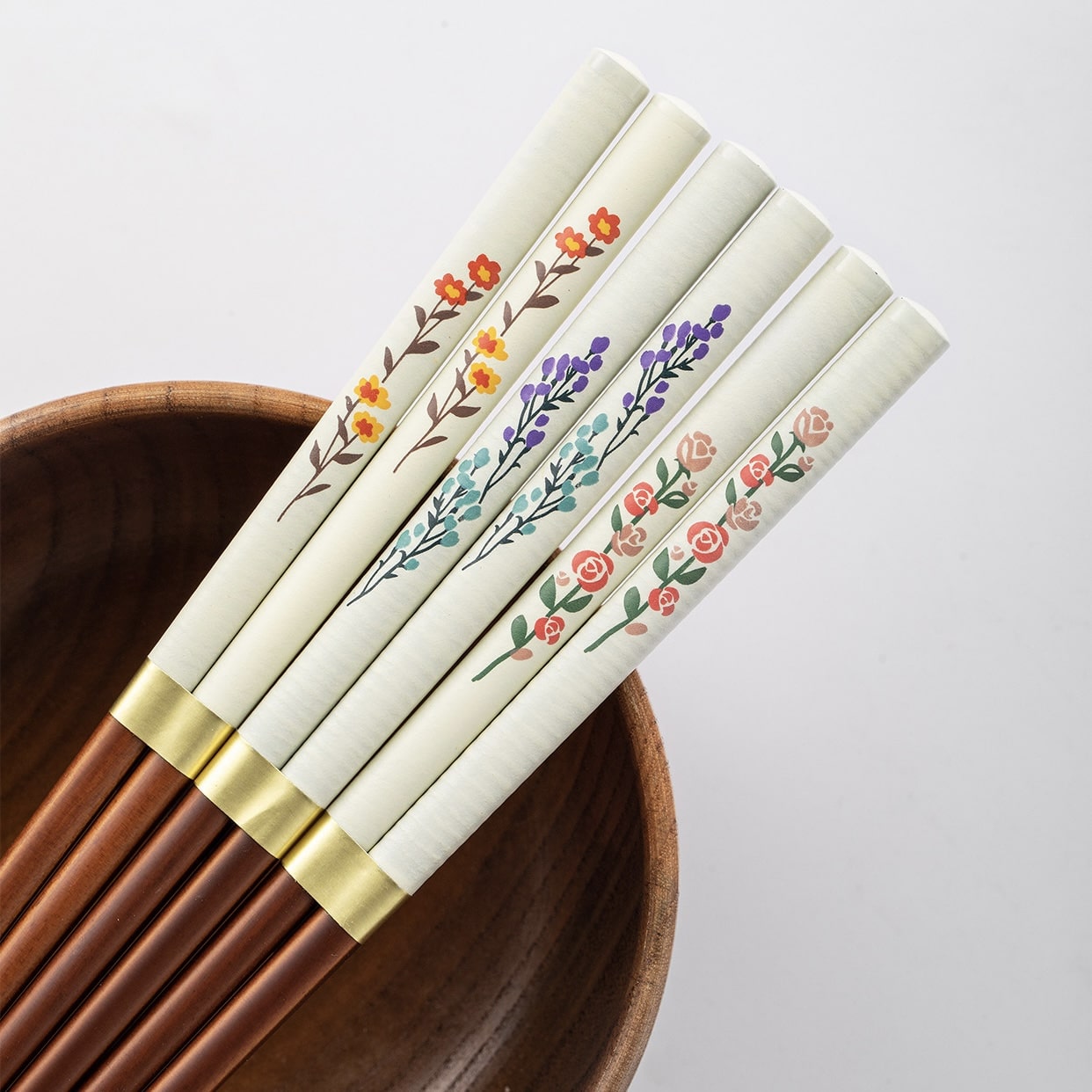 Close-up of hand-painted floral chopsticks on a wooden table