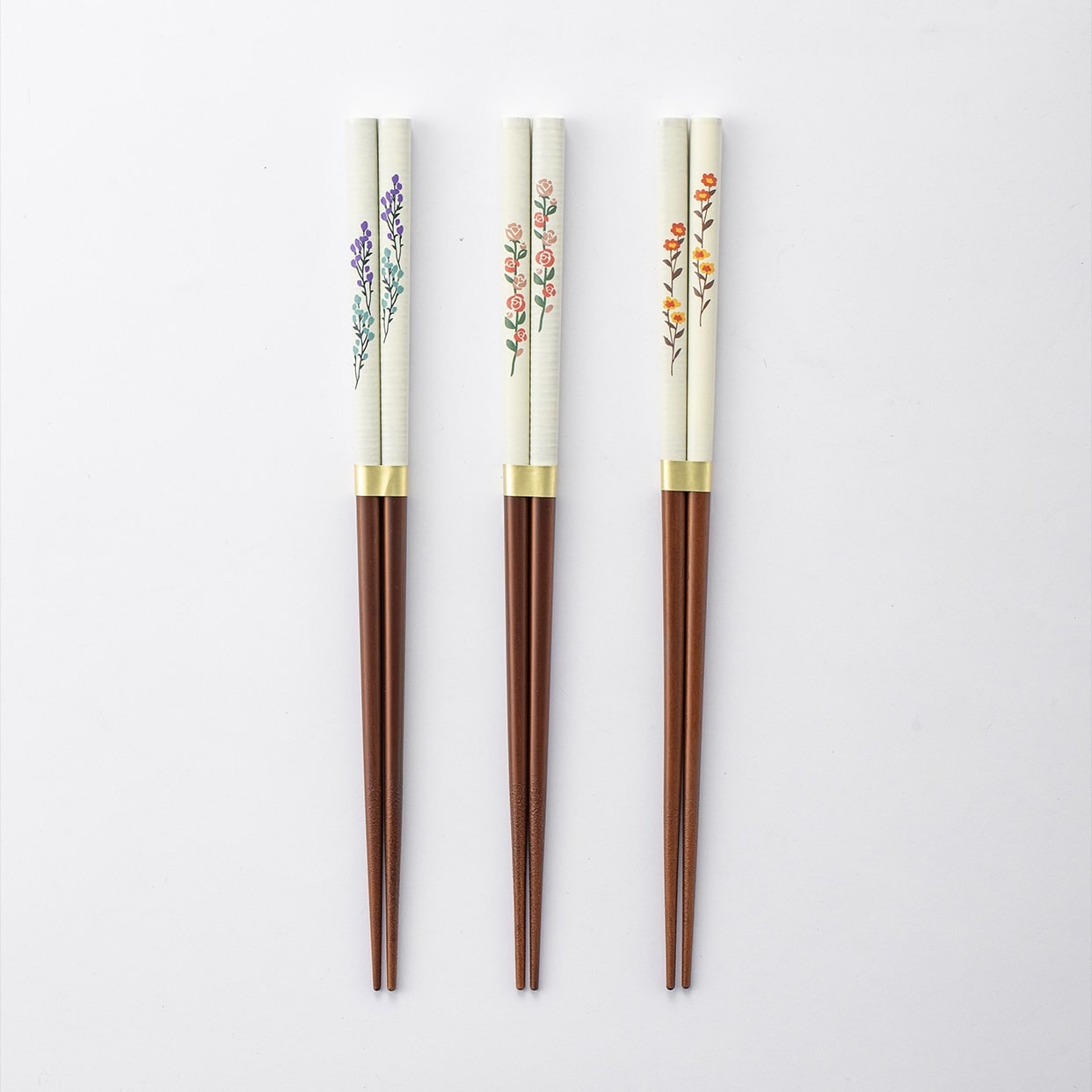 Close-up of hand-painted floral Japanese chopsticks on a wooden table